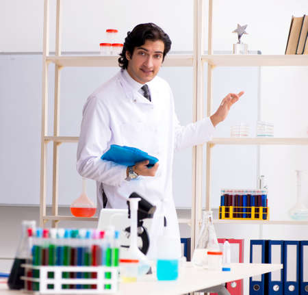 The young handsome chemist working in the lab