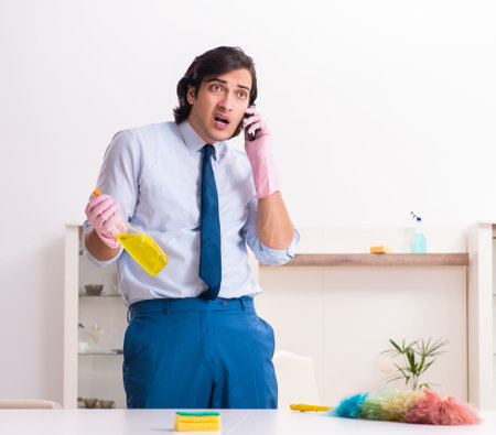 Young businessman cleaning the houseの写真素材