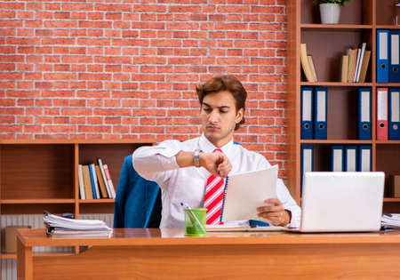 Young handsome employee sitting in the officeの写真素材