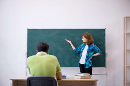 Young teacher and student in the classroomの写真素材