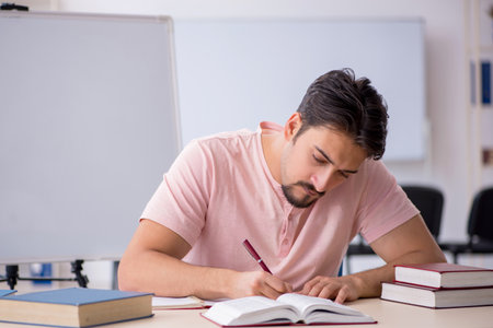Young male student preparing for exams in the classroomの写真素材