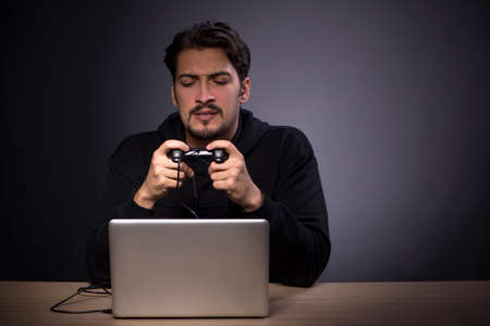 Young male gamer on grey backgroundの写真素材