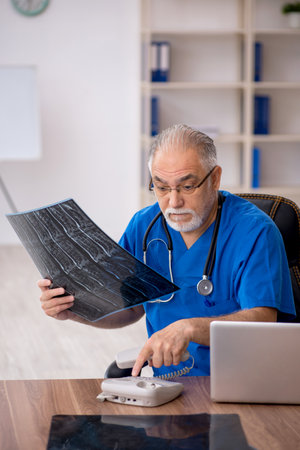 Old male doctor radiologist working in the clinicの写真素材