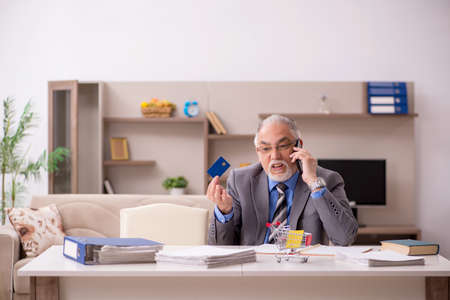 Old male employee in e-commerce concept during pandemicの写真素材