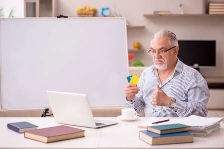 Old male employee working from home during pandemicの写真素材