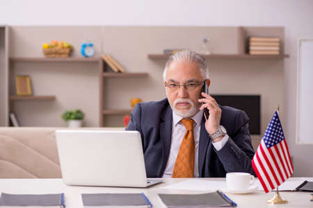 Old male employee working from home during pandemicの写真素材