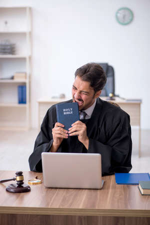 Young male judge taking oath on holly bibleの写真素材