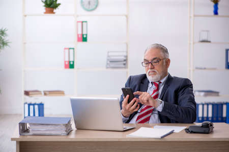 Old male employee working in the officeの写真素材