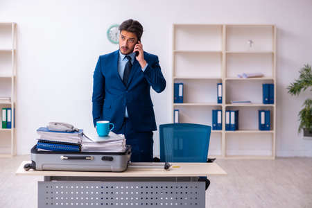 Young male employee preparing for business trip at workplaceの写真素材