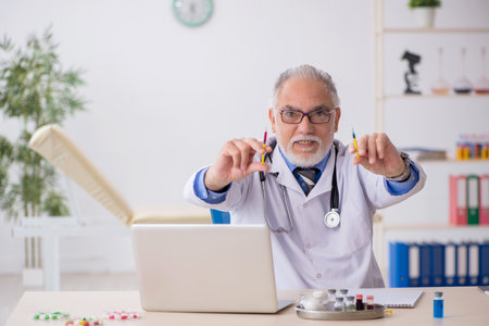 Old male doctor pharmacist working at the labの写真素材