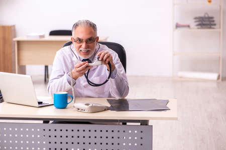 Aged male doctor working in the clinicの写真素材