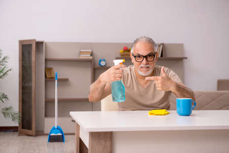 Old man doing housework at home