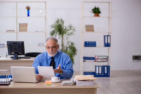 Old male employee working in the officeの写真素材