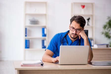 Young male doctor in telemedicine conceptの写真素材