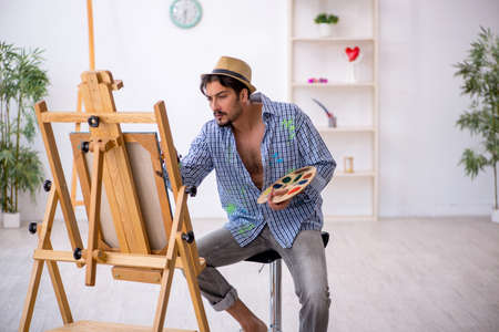 Young man enjoying painting at the studioの写真素材