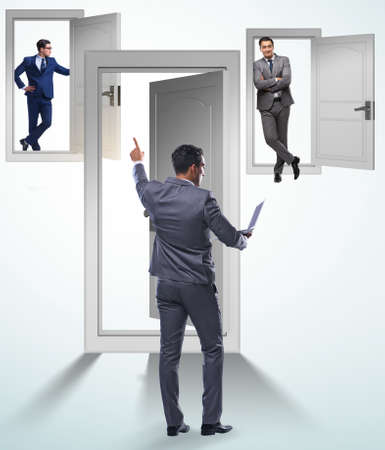 Businessman in uncertainty concept with many doorsの写真素材