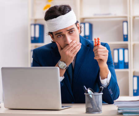 Head injured male employee working in the officeの写真素材