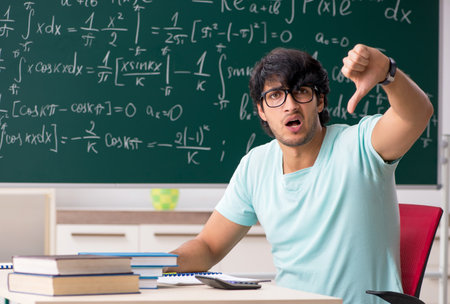 Young male student mathematician in front of chalkboardの写真素材