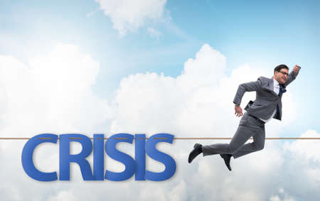Crisis concept with businessman walking on tight rope