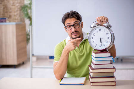 Young male student in time management conceptの写真素材