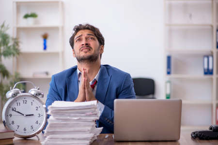 Young male employee in time management conceptの写真素材