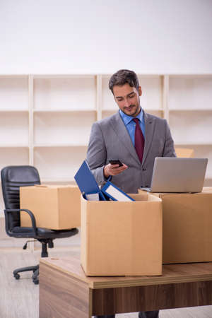Young male employee in office relocation conceptの写真素材