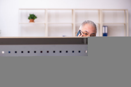 Old male employee working at workplaceの写真素材