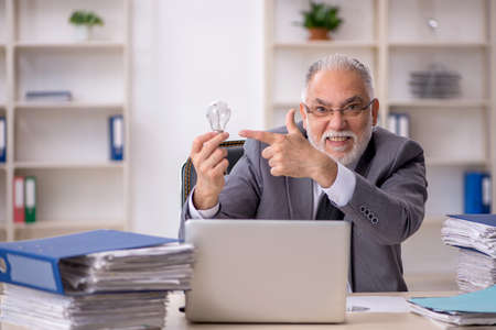 Old male employee in happy idea conceptの写真素材