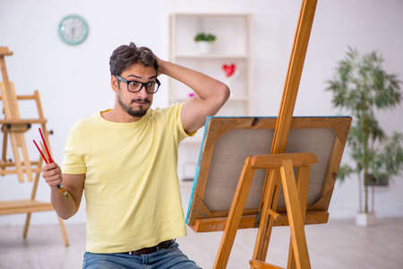 Young man enjoying painting at homeの写真素材