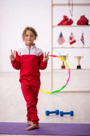 Young little girl doing sport exercises at homeの写真素材