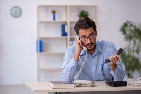 Young male call center operator working at his deskの写真素材
