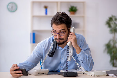 Young male call center operator working at his deskの写真素材