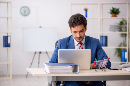Young male employee in e-commerce conceptの写真素材