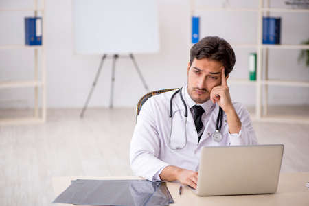 Young male doctor in telemedicine conceptの写真素材