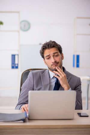 Young male employee sitting at workplaceの写真素材
