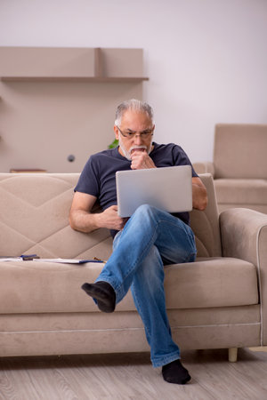 Old male employee working from home during pandemicの写真素材