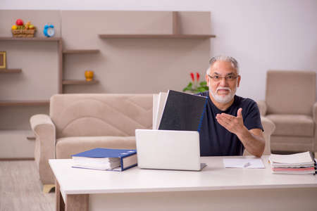 Old male employee working from home during pandemicの写真素材