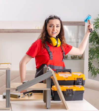 Female contractor repairing furniture at homeの写真素材