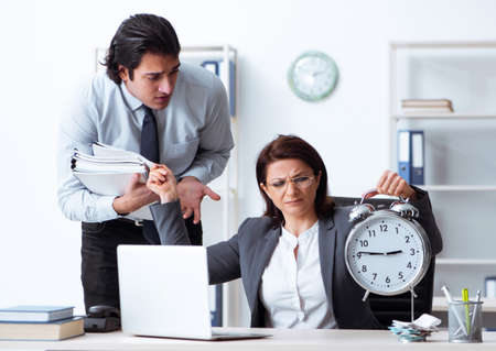 Old female boss and young male employee in the officeの写真素材