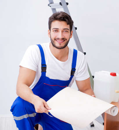 Repairman doing renovation repair in the house with paper wallpaの写真素材