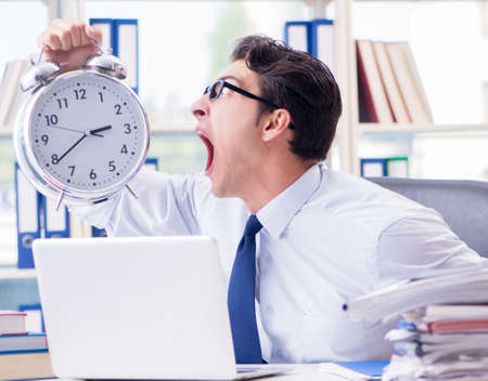 Businessman missing deadline for deliverables in officeの写真素材