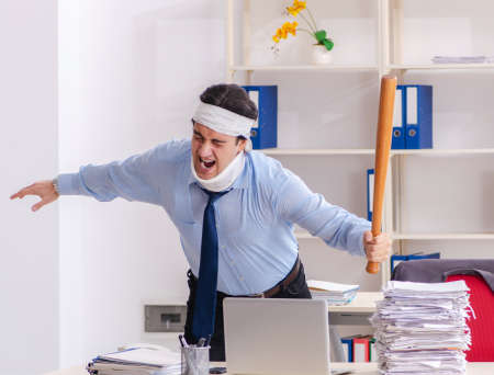 Young injured male employee working in the officeの写真素材