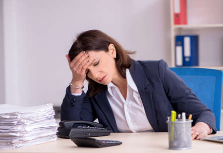 Middle-aged female employee suffering in the officeの写真素材