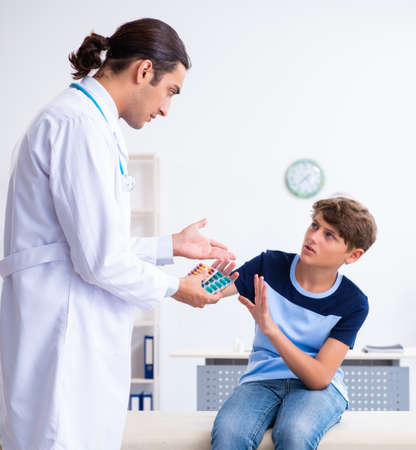 Young male doctor examining boy in the clinicの写真素材