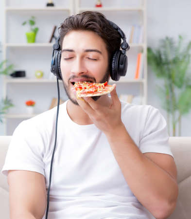 Man eating pizza having a takeaway at home relaxing restingの写真素材
