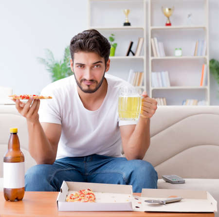 Man eating pizza having a takeaway at home relaxing restingの写真素材