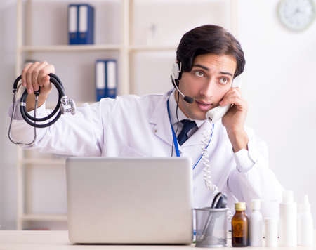 Young male doctor in telemedicine conceptの写真素材