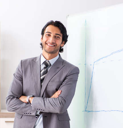 Young handsome businessman in front of whiteboardの写真素材