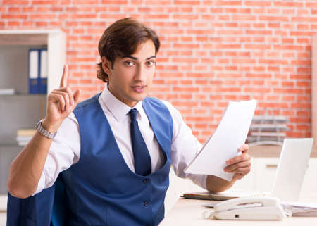 Young handsome employee working in the officeの写真素材