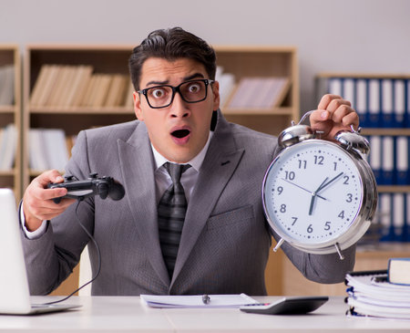 Businessman playing computer games at work officeの写真素材